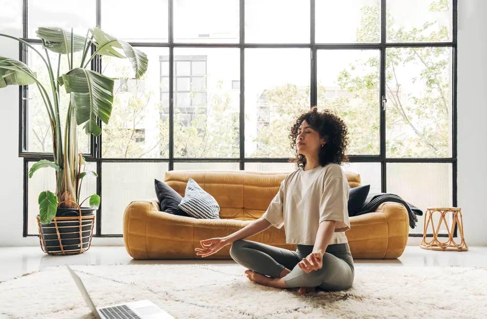 Woman meditating in her apartment.