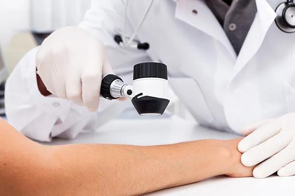 A dermatologist checks a patient's arm