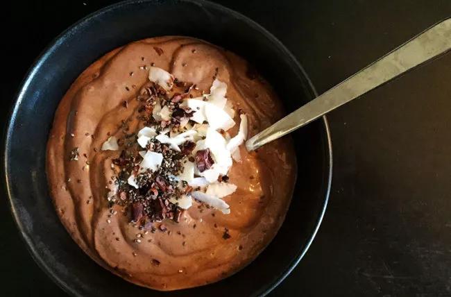 Bowl of chocolate pudding, with chia seeds and coconut shavings