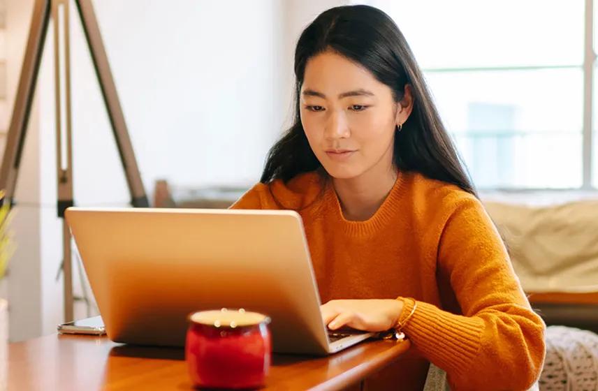 Woman sitting at coffee table on laptop