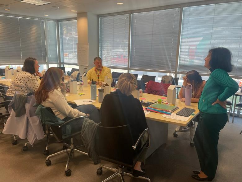 An image of people around a conference table.