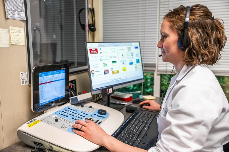 Dr. Karen Petter using the auditory therapy program on a computer in a clinical setting.