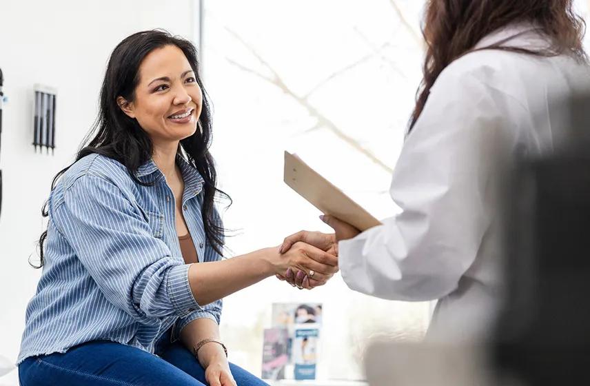 Woman shaking hands with a doctor.