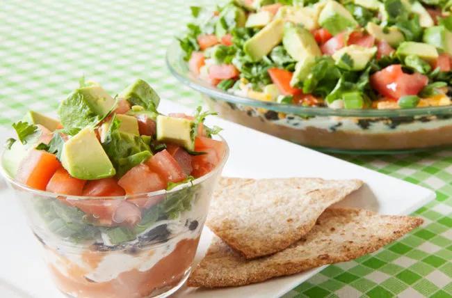 Eight-layer taco salad in cup and in serving dish