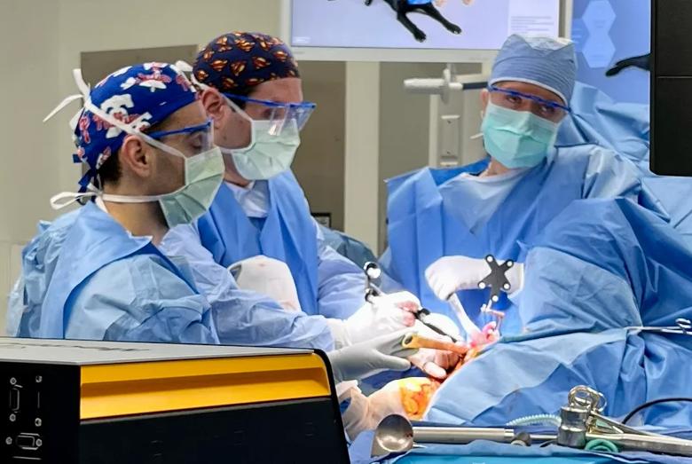 Three surgeons performing shoulder surgery