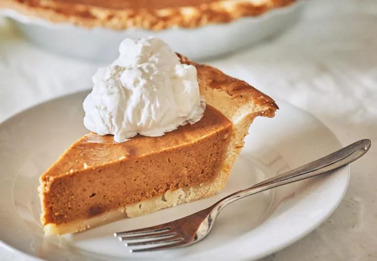 slice of pumpkin pie on a plate with a fork