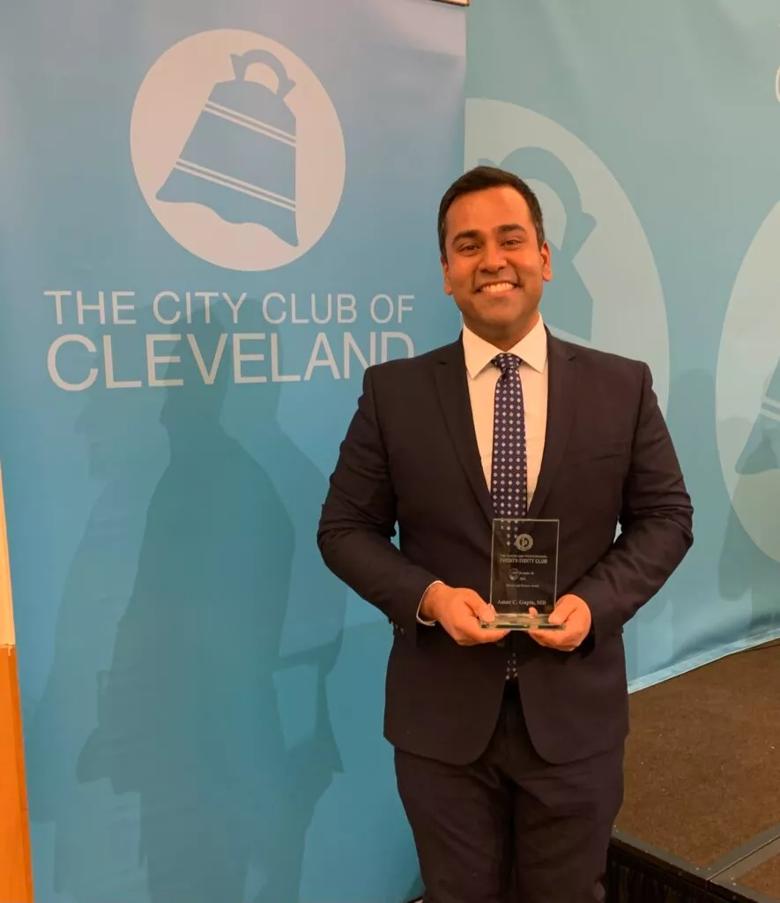 Amar Gupta, MD holding an award.