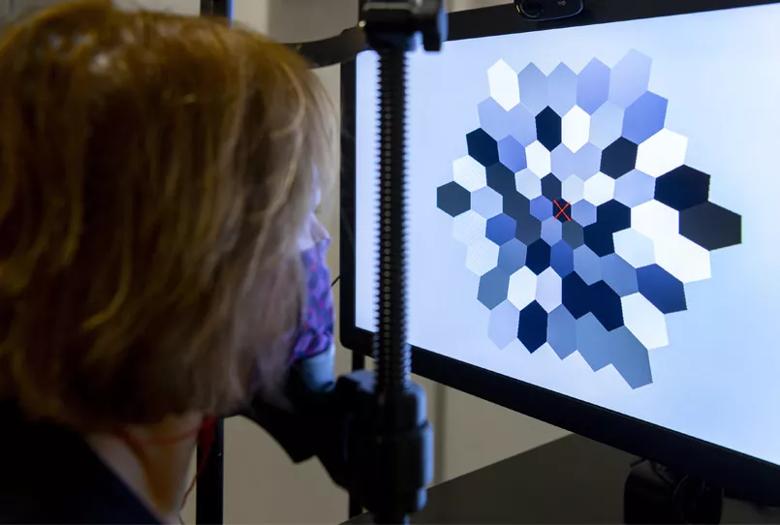 Patient looking at a monitor displaying a hexagon with different colored spots