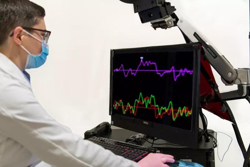The doctor looks at a screen with different colored zig-zags