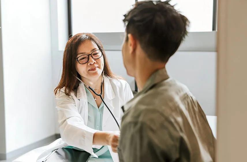 Caregiver checking a patient's heart with a stethoscope