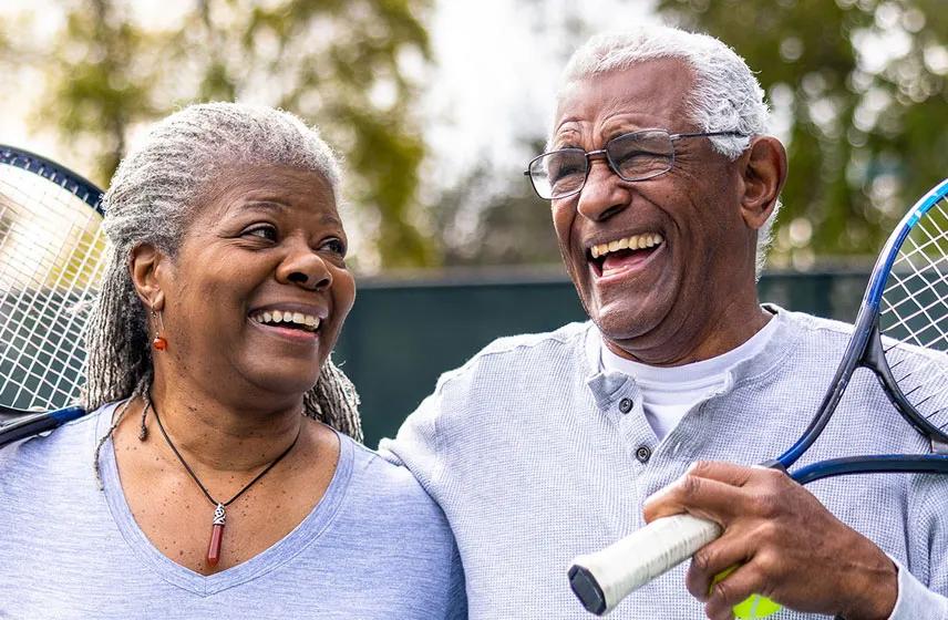Happy couple playing tennis.