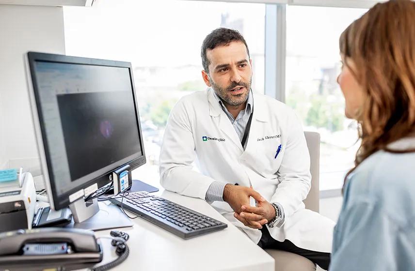 Caregiver talking to a patient in a medical office.