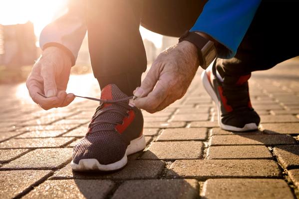 Senior runner tying sneakers