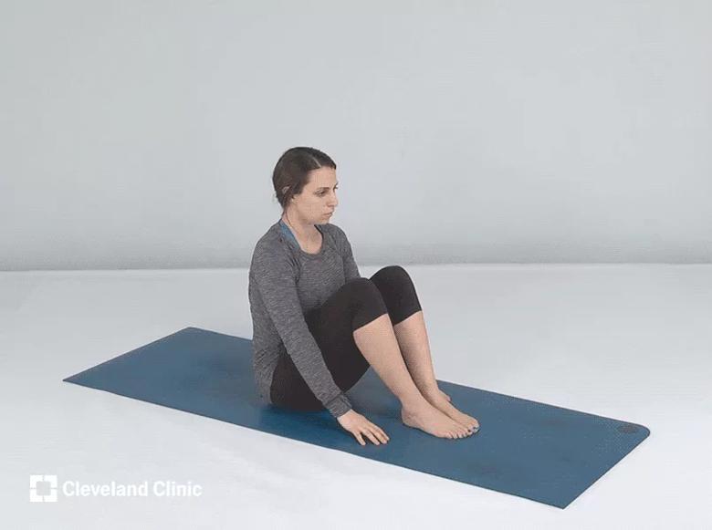 Person sitting on mat, knees up