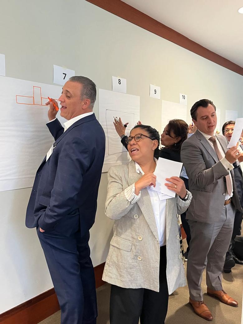 Business professionals working on a task, writing on papers posted on a wall
