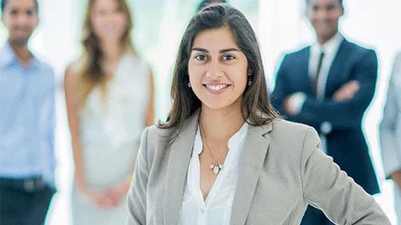 Business professional gathered around her colleagues.