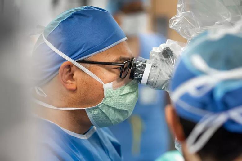 Surgeon looking into an operating microscope