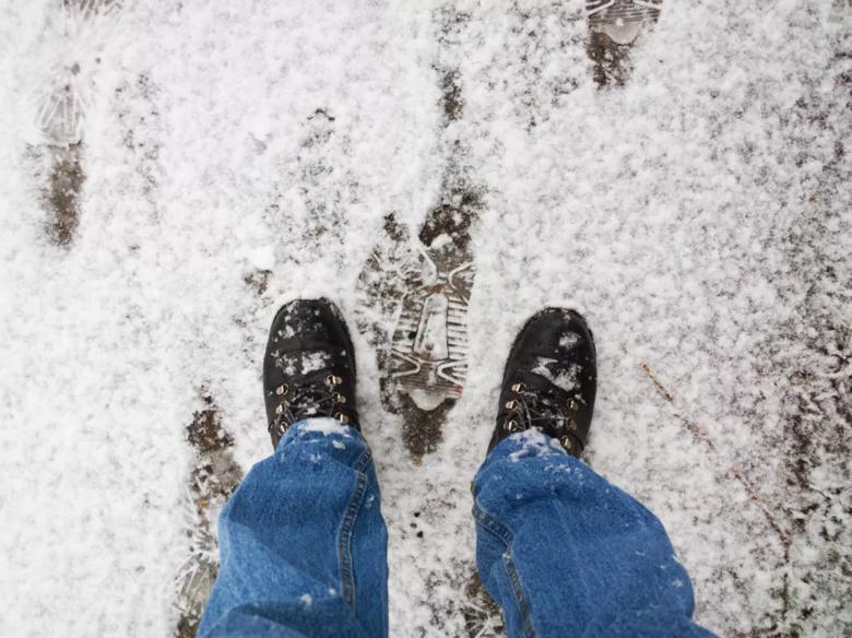 man wearing boots outside with snow on the ground
