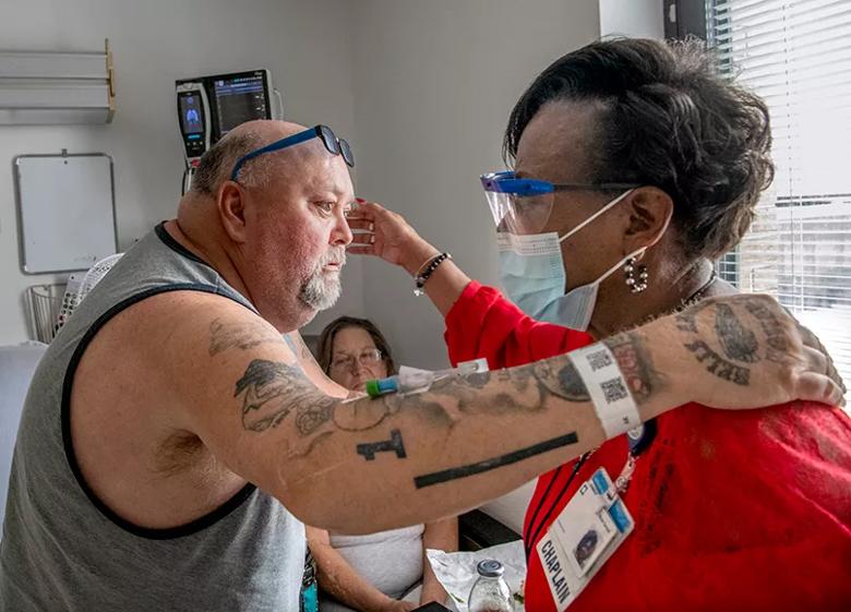 Chaplain hugs patient