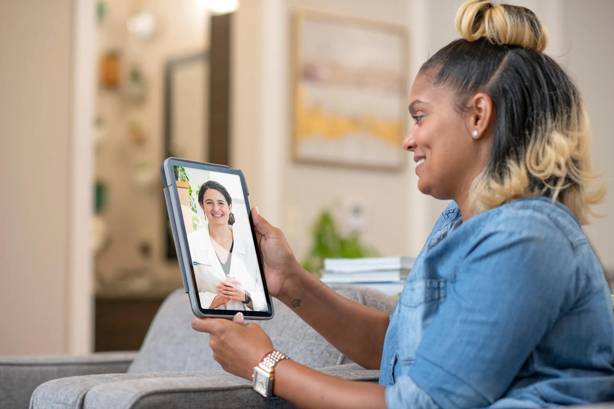 Woman talking to Cleveland Clinic expert on tablet.