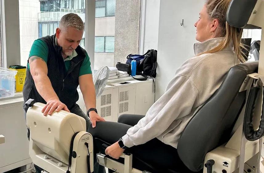 Caregiver examining a patient's knee.