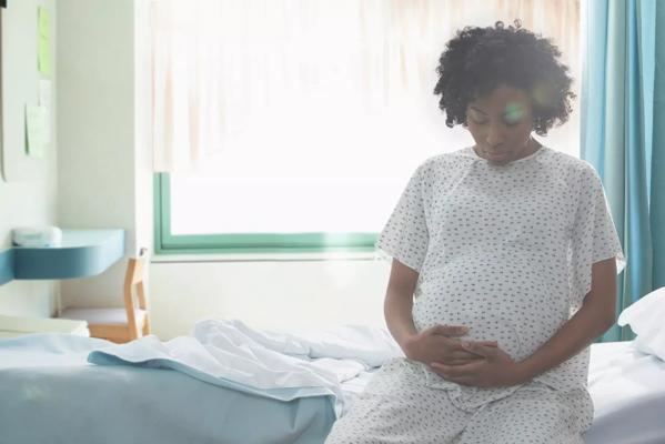 Pregnant minority woman in hospital bed