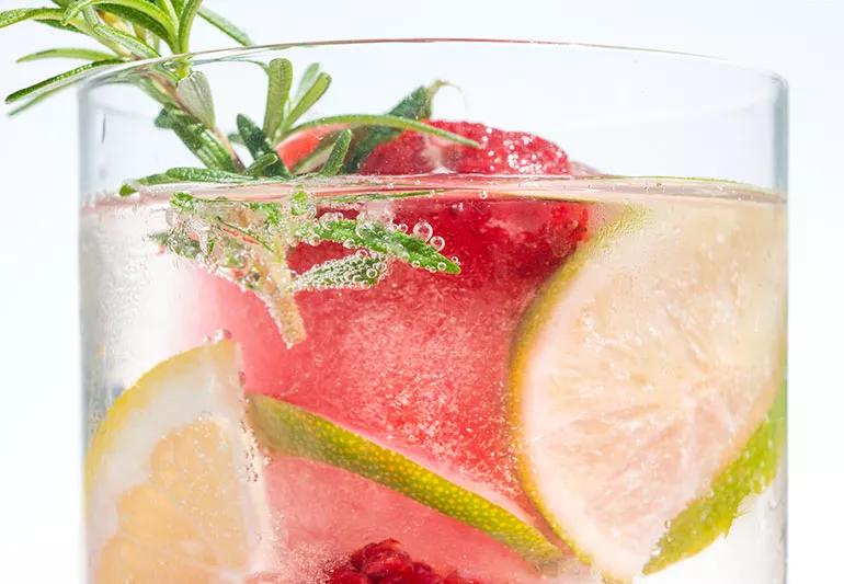 Slices of lemon, lime, watermelon and strawberries in a glass of water