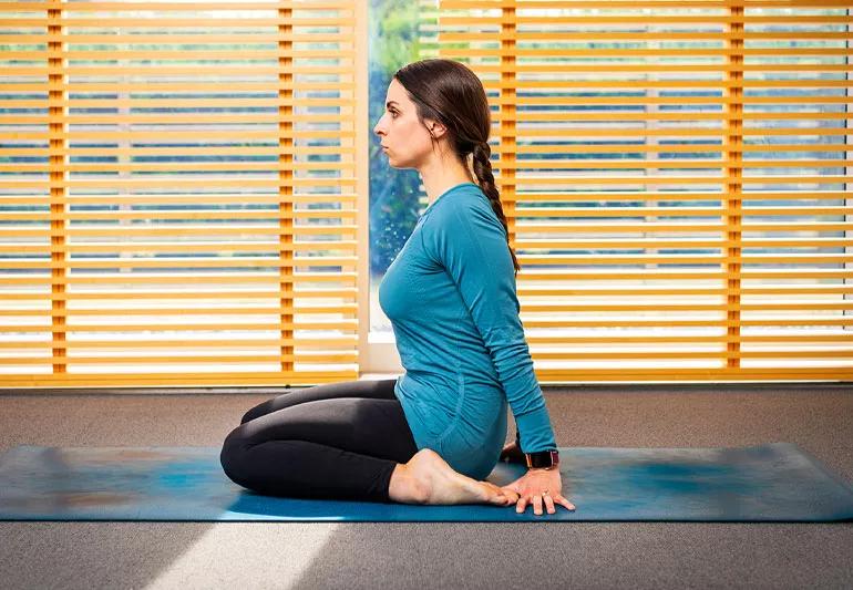 person on yoga mat in hero pose