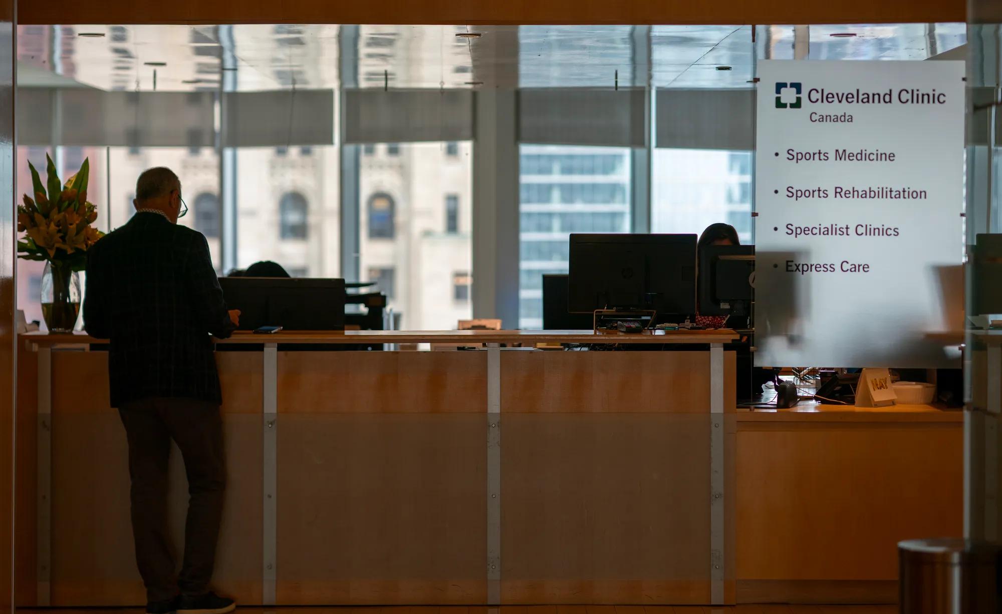 Patient standing at check in desk at Cleveland Clinic Canada office