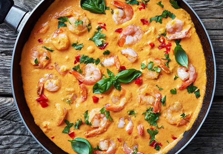 A pan of tomato-basil soup with shrimp