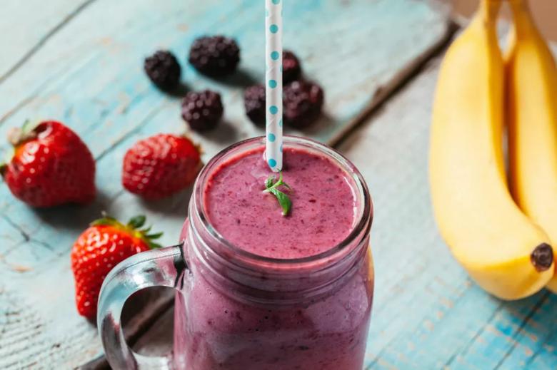 smoothie with strawberries and bananas next to it