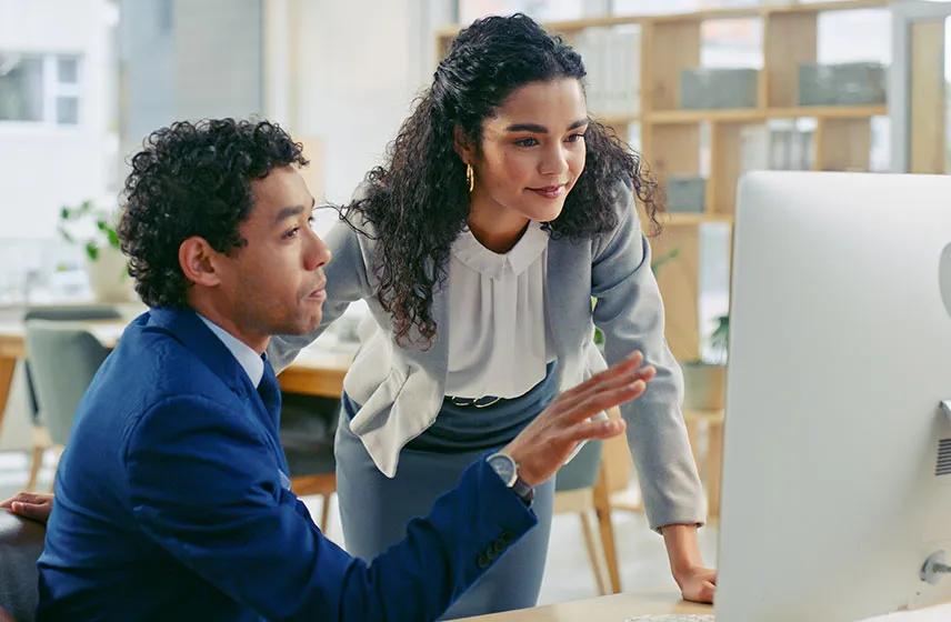 Two employees looking at a computer screen