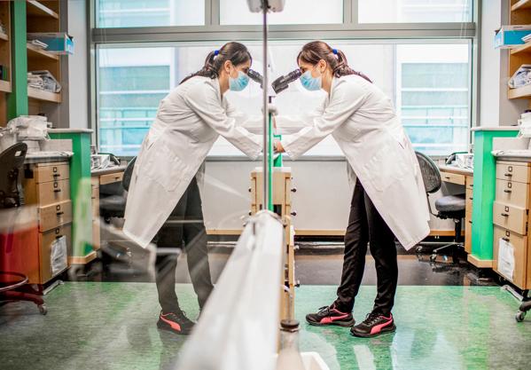 A Cleveland Clinic researcher looking through a microscope.