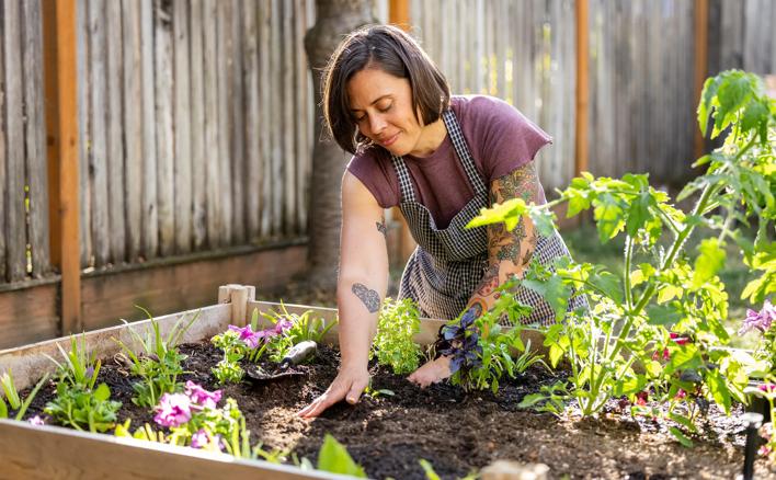 Person working in container garden flower bed