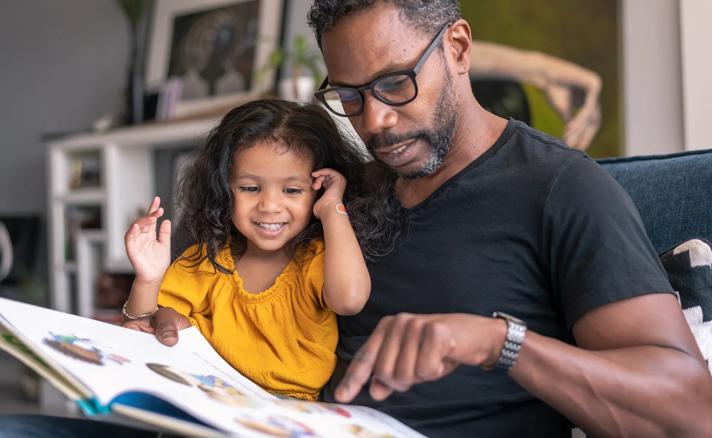 Caregiver reading to a happy young child