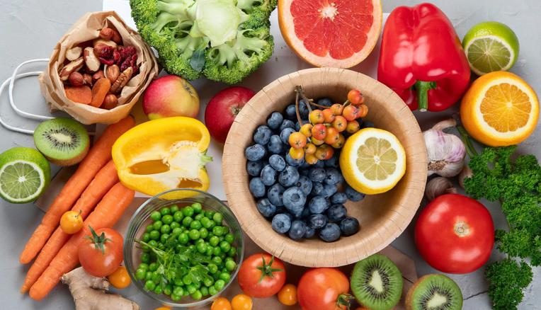 Assorted foods with vitamin C, including blueberries, broccoli, nuts and tomatoes