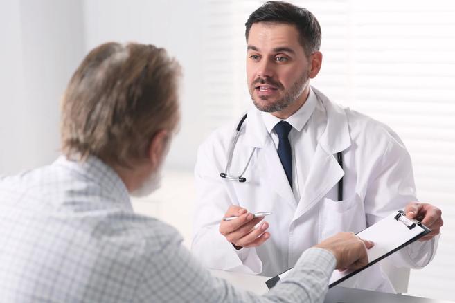 Urologist speaking to man in clinic