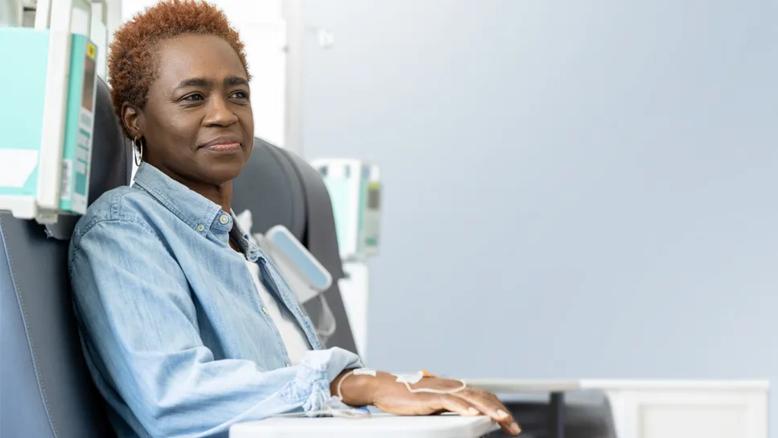 Woman sitting in a chair and receiving a drug infusion