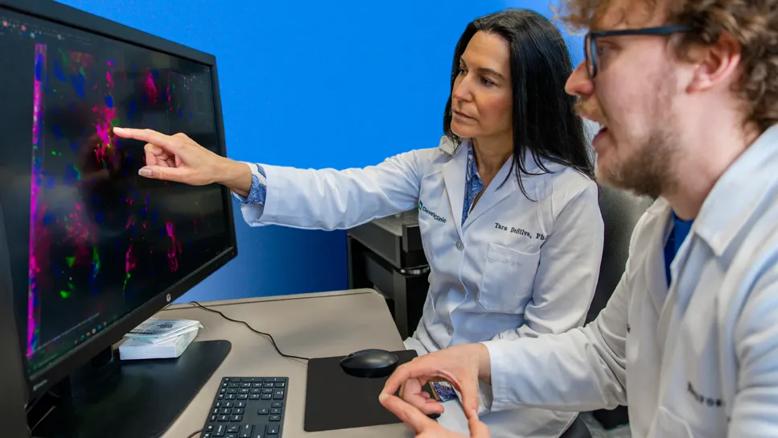 Image of Dr. Tara DeSilva with associate looking at computer
