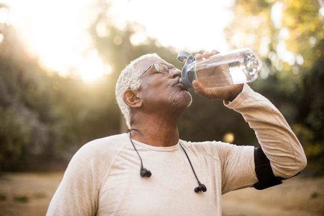 Man drinking water while exercising