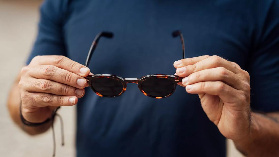 Person holding up sunglasses