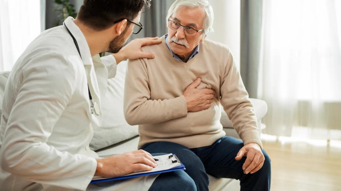 Healthcare provider with hand on older patient's shoulder, discussing heart