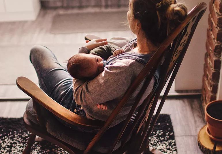 Mom rocking her baby to sleep in rocking chair