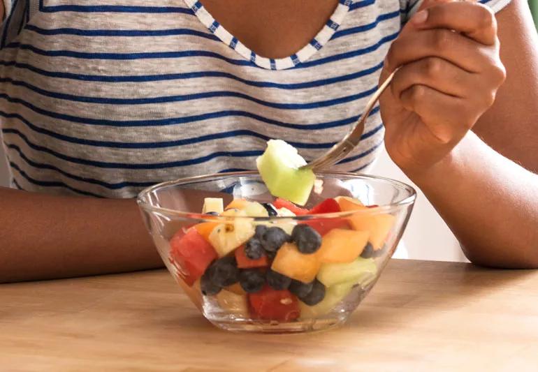 woman eating fruit salad