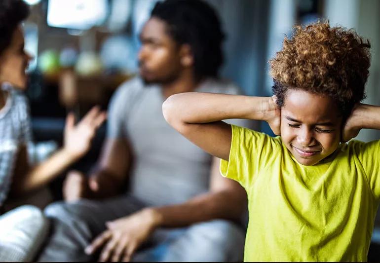 child covering ears because parents are arguing