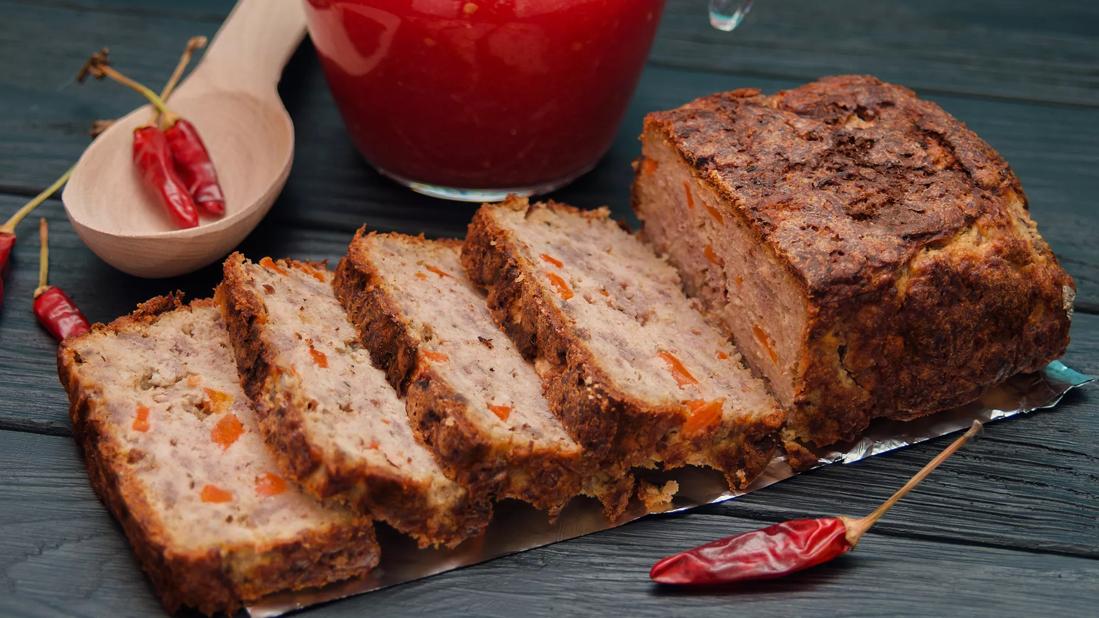 Mexican turkey meatloaf, sliced, with hot red peppers around loaf