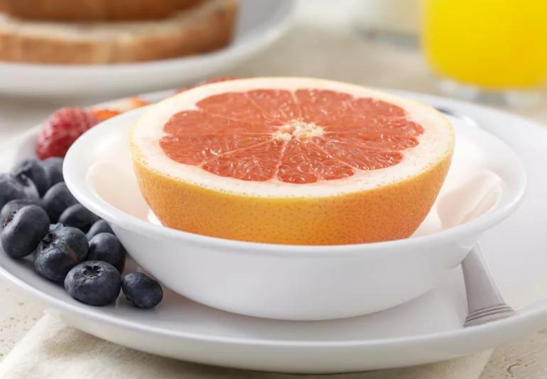 half of a grapefruit sitting in a bowl
