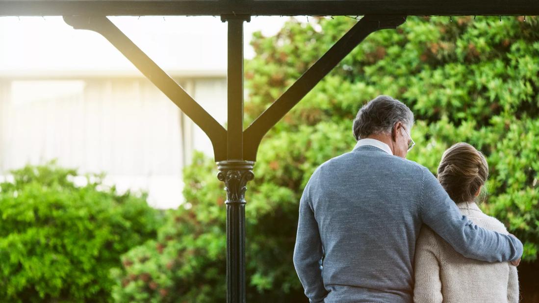 A senior couple embracing with their backs facing the camera