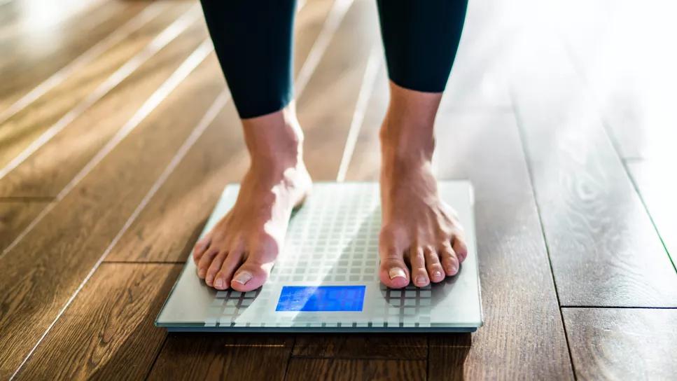 Patient weighing herself on scale