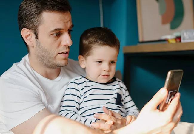 father and toddler use telemedicine